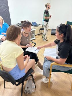 3 Frauen sitzen zusammen im Austausch.