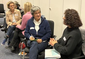 Frauen sitzen in Zweiergruppen.