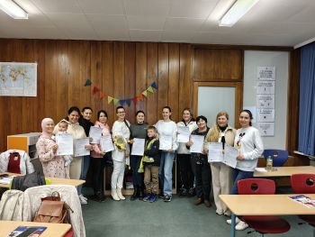 12 qualifizierte Elternmentoren/-innen zeigen freudig ihre Urkunden.