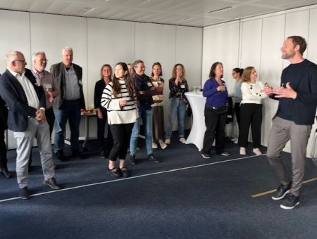 Dr. Oliver Borszik leitet Teilnehmende an, die hinter einer Linie stehen.